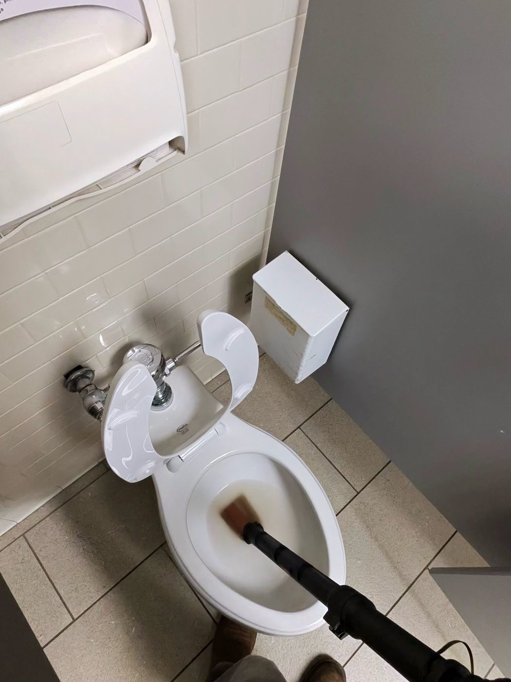 Toilet auger feeding into a clogged commercial toilet in Pinellas Park, FL